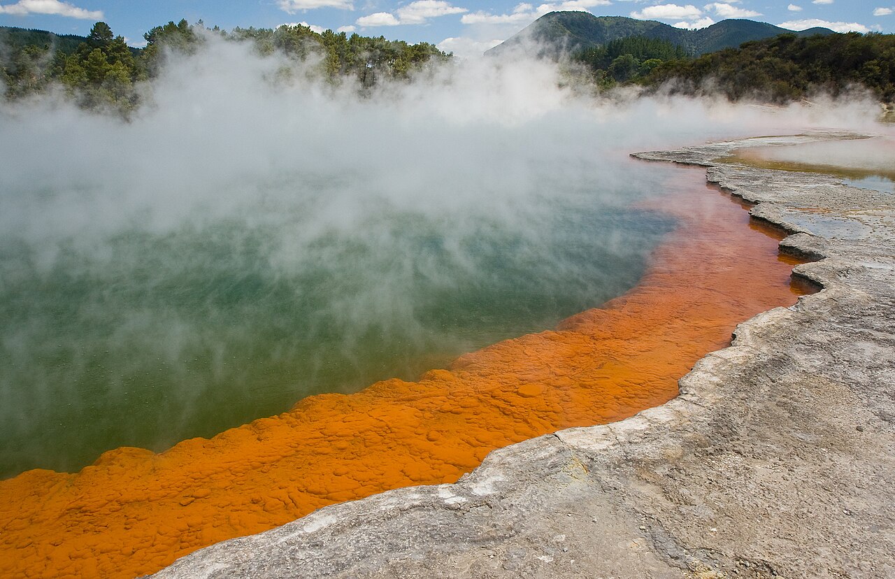 The Champagne Pool at Wai-O-Tapu with vibrant orange silica edge and steaming geothermal water